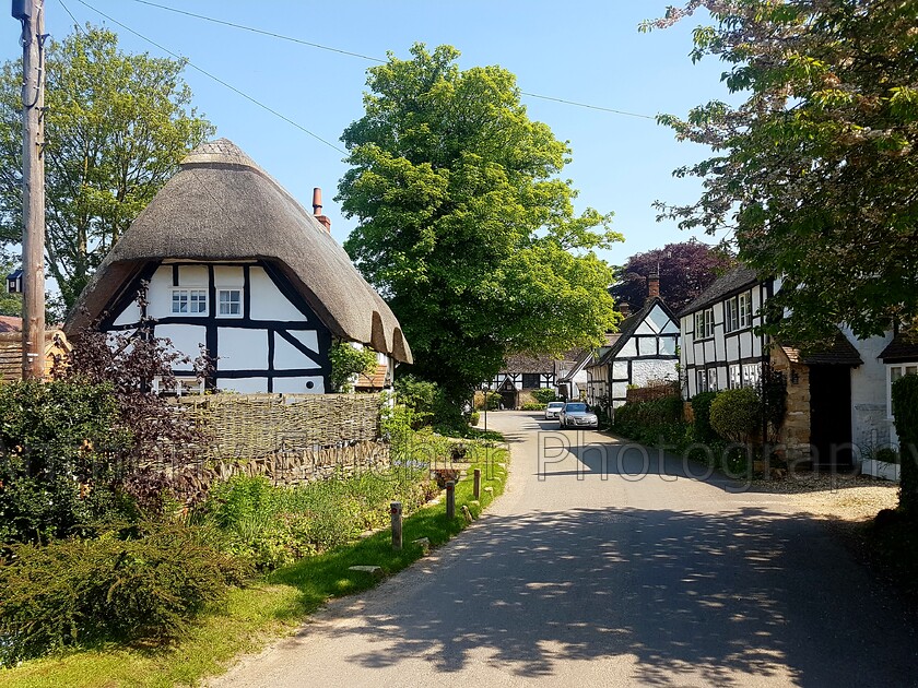 English village 
 A quaint traditional English village shot in the summer 
 Keywords: english, village, summer, black white, landscape, landscape photography, travel, travel photography, road, lane, quaint, thatched cottage,